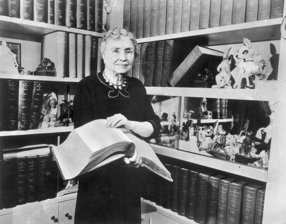 Helen Keller holding a Braille volume