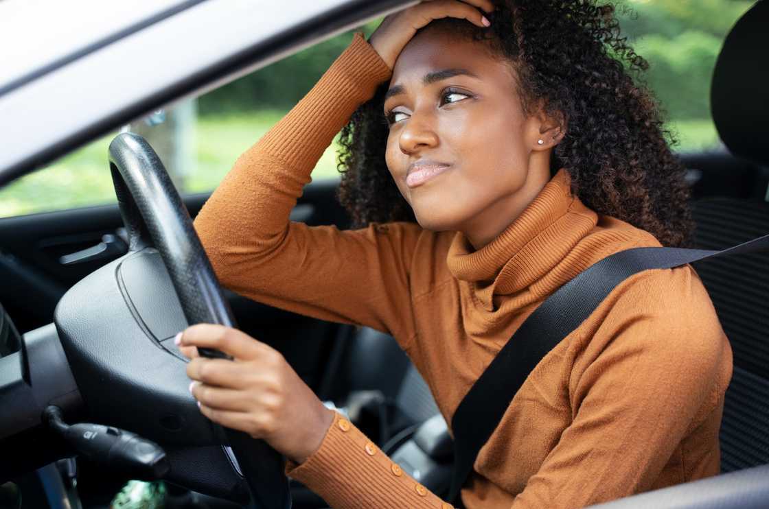A frustrated woman driving, seemingly worried
