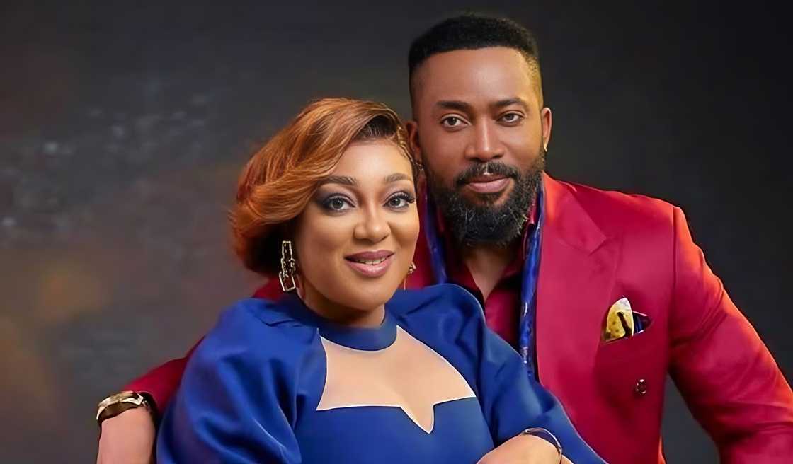 Frederick Leonard and Peggy Ovire pose sitting as they hold each other