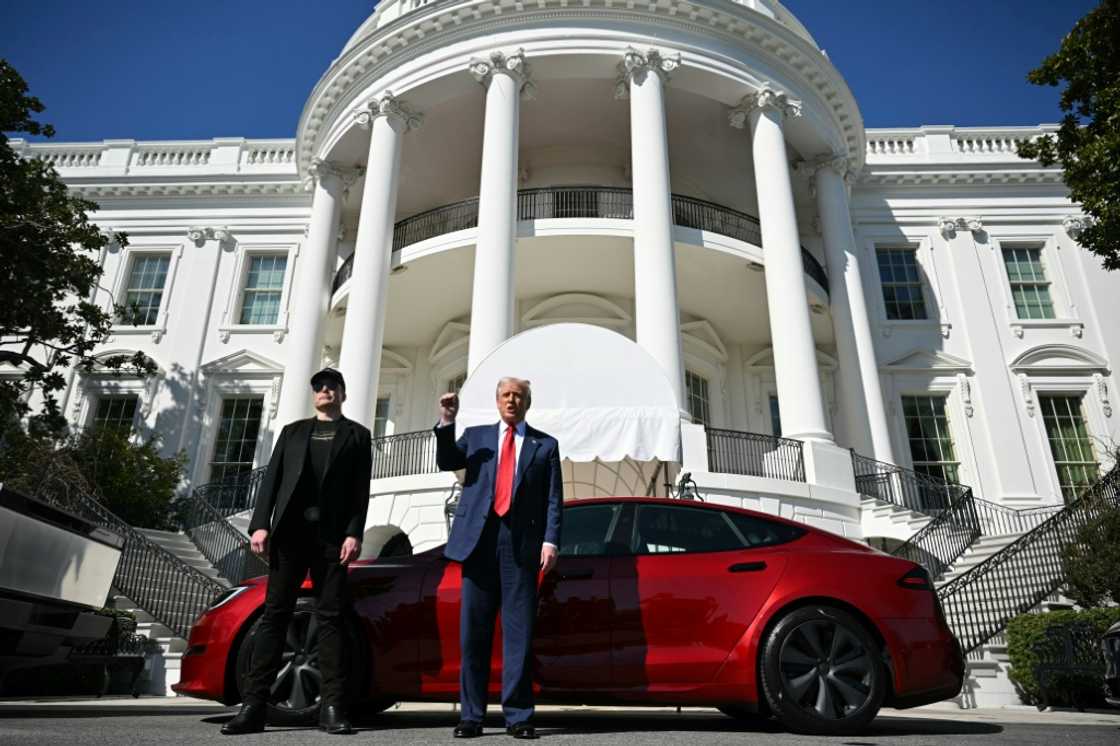 US President Donald Trump and Tesla CEO Elon Musk speak to the press as they stand next to a Tesla vehicle on the South Portico of the White House on March 11, 2025 in Washington, DC