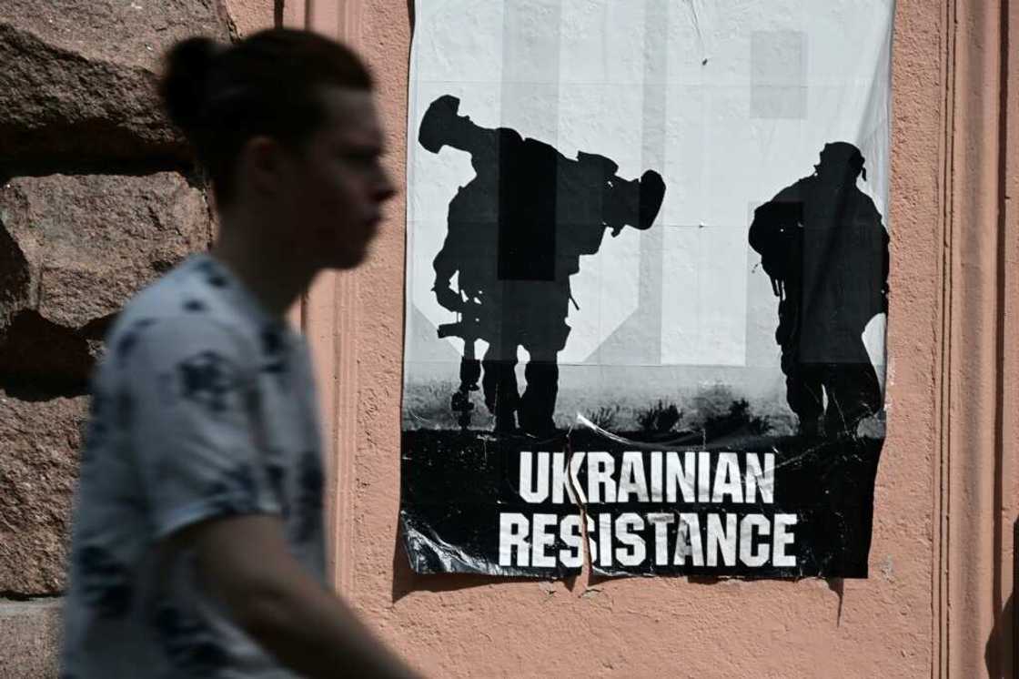 A man passes by a poster reading "Ukrainian Resistance" in central Kyiv, on June 30, 2022 amid the Russian invasion of Ukraine A man passes by a poster reading "Ukrainian Resistance" in central Kyiv, on June 30, 2022 amid the Russian invasion of Ukraine