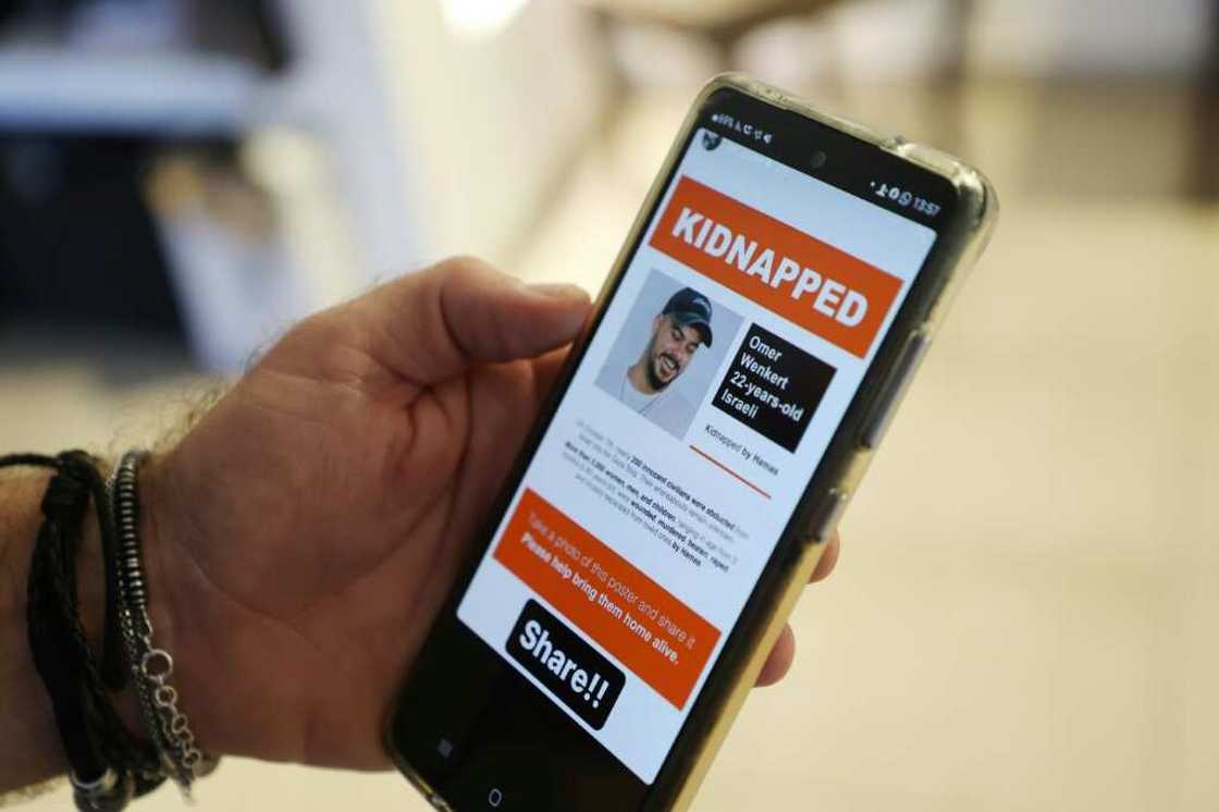 Shay Wenkert, the father of Israeli hostage Omer Wenkert who Hamas gunmen abducted from a music festival, shows an image of his son on a phone Shay Wenkert, the father of Israeli hostage Omer Wenkert who Hamas gunmen abducted from a music festival, shows an image of his son on a phone