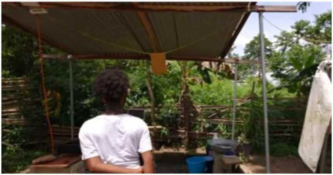 The girl stares at a structure that serves as their kitchen The girl stares at a structure that serves as their kitchen