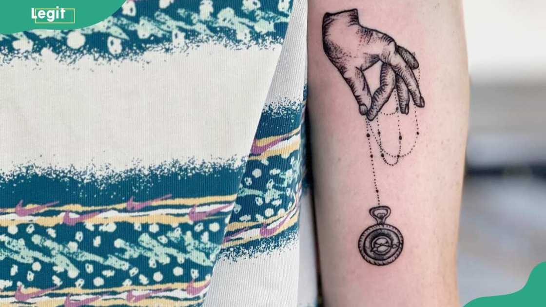 Clock with a pendulum tattoo