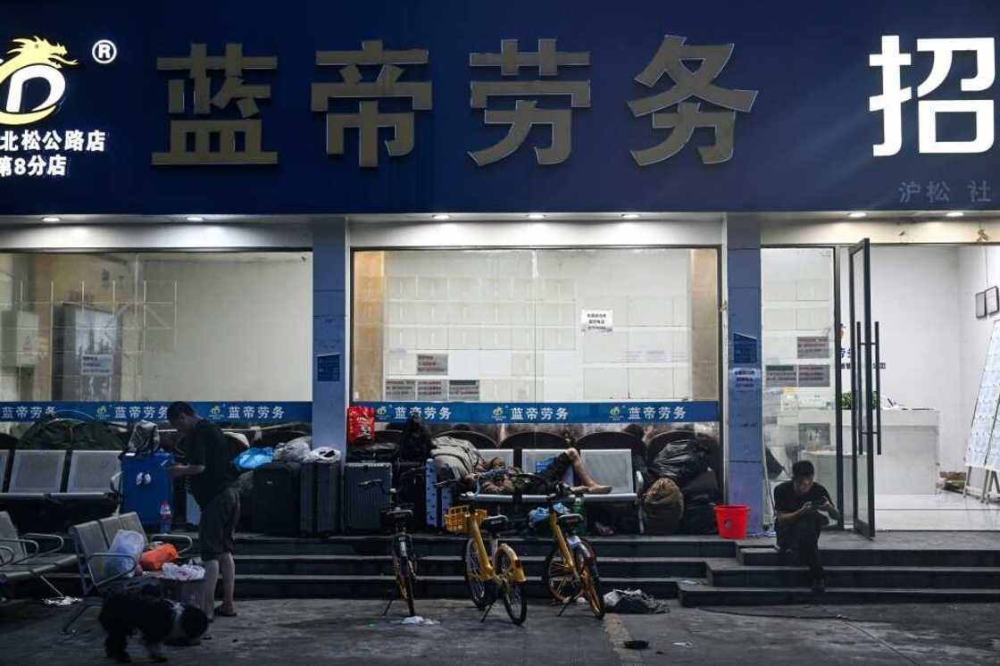 People wait outside an employment agency in Shanghai