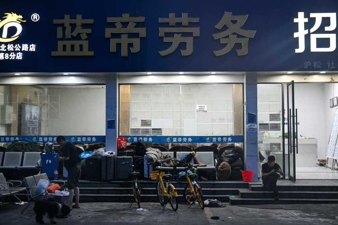 People wait outside an employment agency in Shanghai People wait outside an employment agency in Shanghai