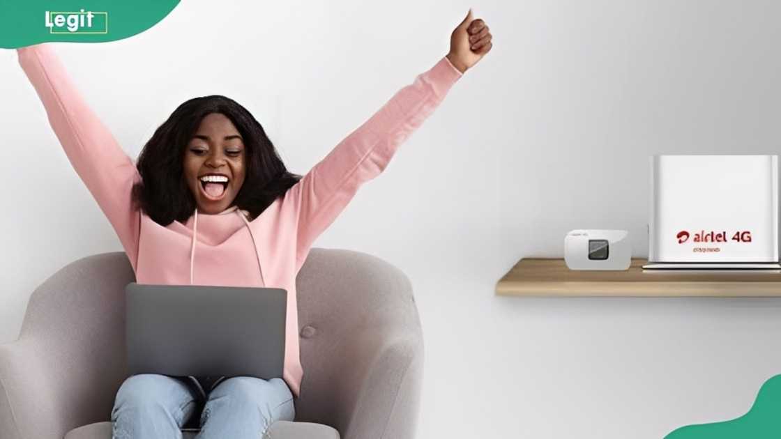 A lady rejoices as she uses her laptop