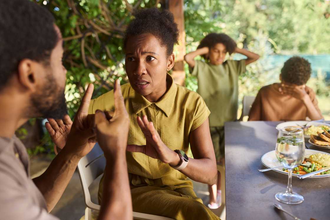 A couple argues during a family lunch.