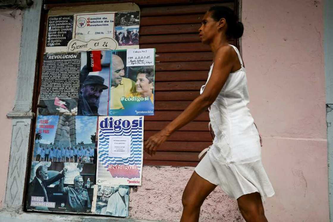 A woman walks past a sign in Havana in favor of the new Family Code A woman walks past a sign in Havana in favor of the new Family Code