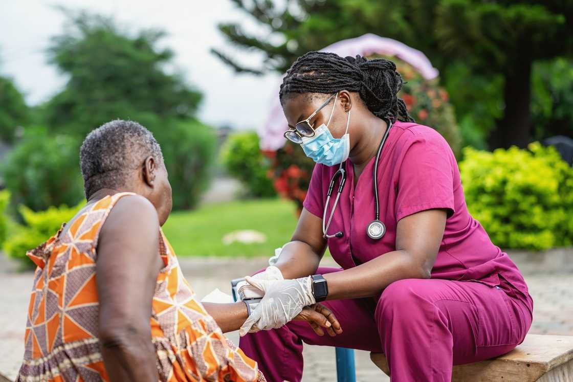 A public health nurse plaing a blood pressure uff on a patient. A public health nurse plaing a blood pressure uff on a patient.
