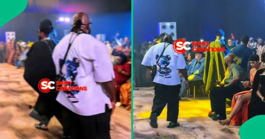 Kizz Daniels' bouncer observes venue as his boss performs on stage.