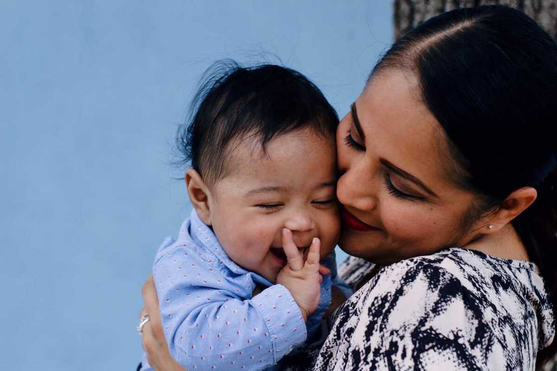 A mother holding her baby smilling