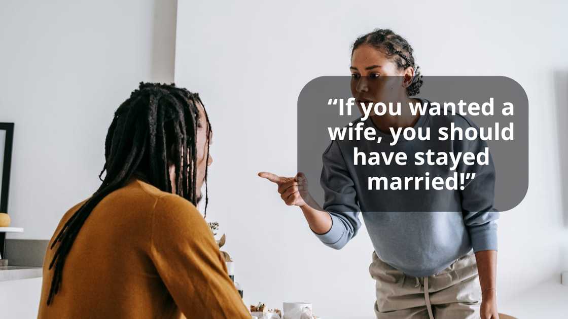 A woman points while speaking to another person seated at a table.