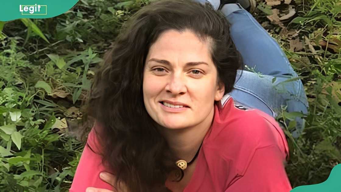 Melanie Rauscher smiles as she lies on a grass lawn