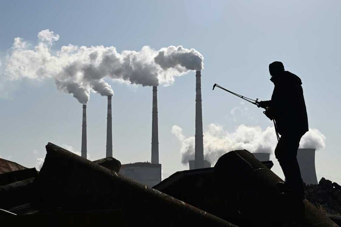 A worker using a torch to cut steel pipes near the coal-powered Datang International Zhangjiakou Power Station in China's northern Hebei province in November 2021 A worker using a torch to cut steel pipes near the coal-powered Datang International Zhangjiakou Power Station in China's northern Hebei province in November 2021