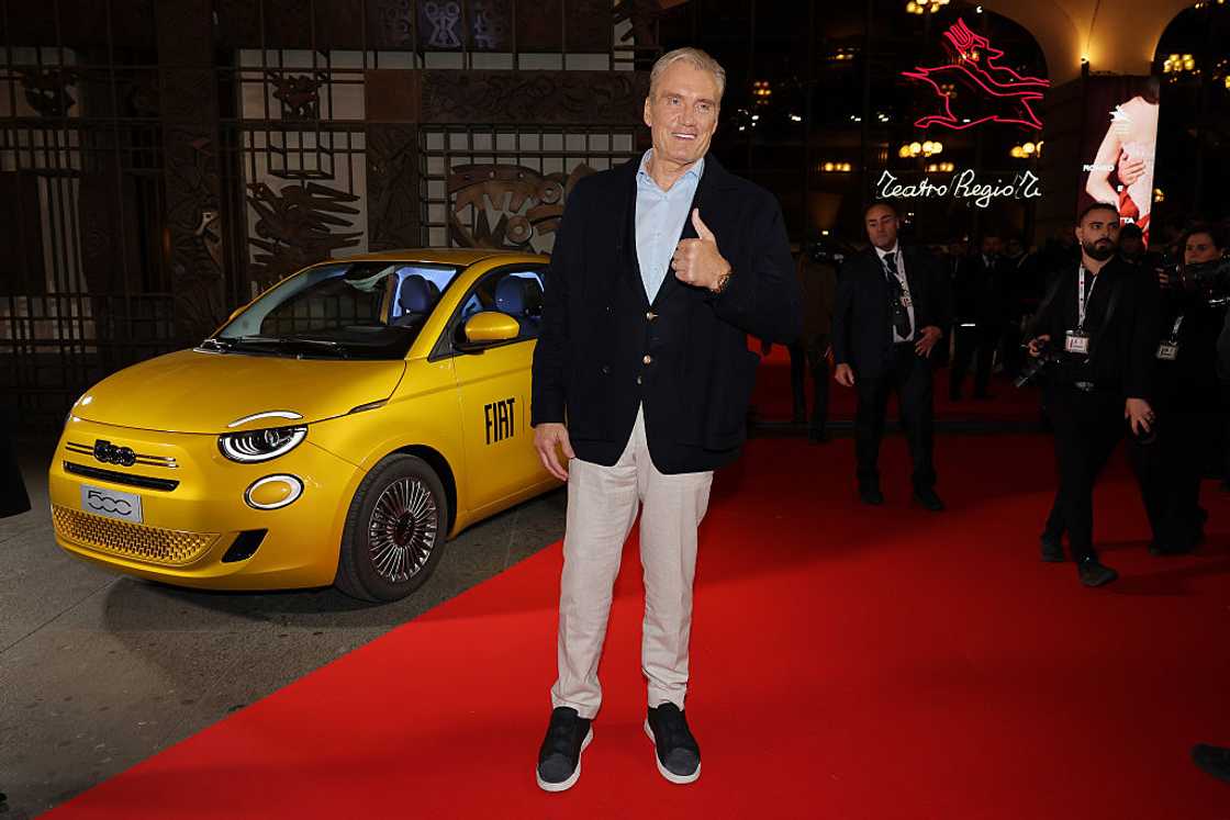 Dolph Lundgren is seen arriving on the red carpet in a black coat and khaki pants