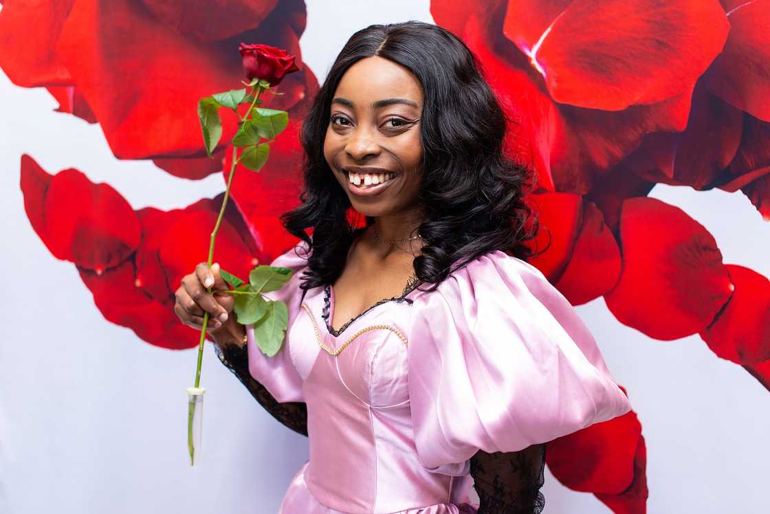 An international student at the University of Helsinki posing with a rose