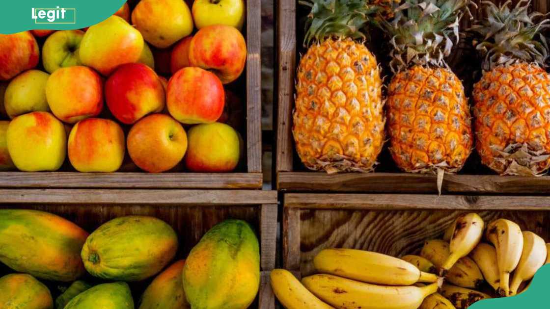 Apples, pineapples, pawpaw and bananas at a fruit stall display Apples, pineapples, pawpaw and bananas at a fruit stall display