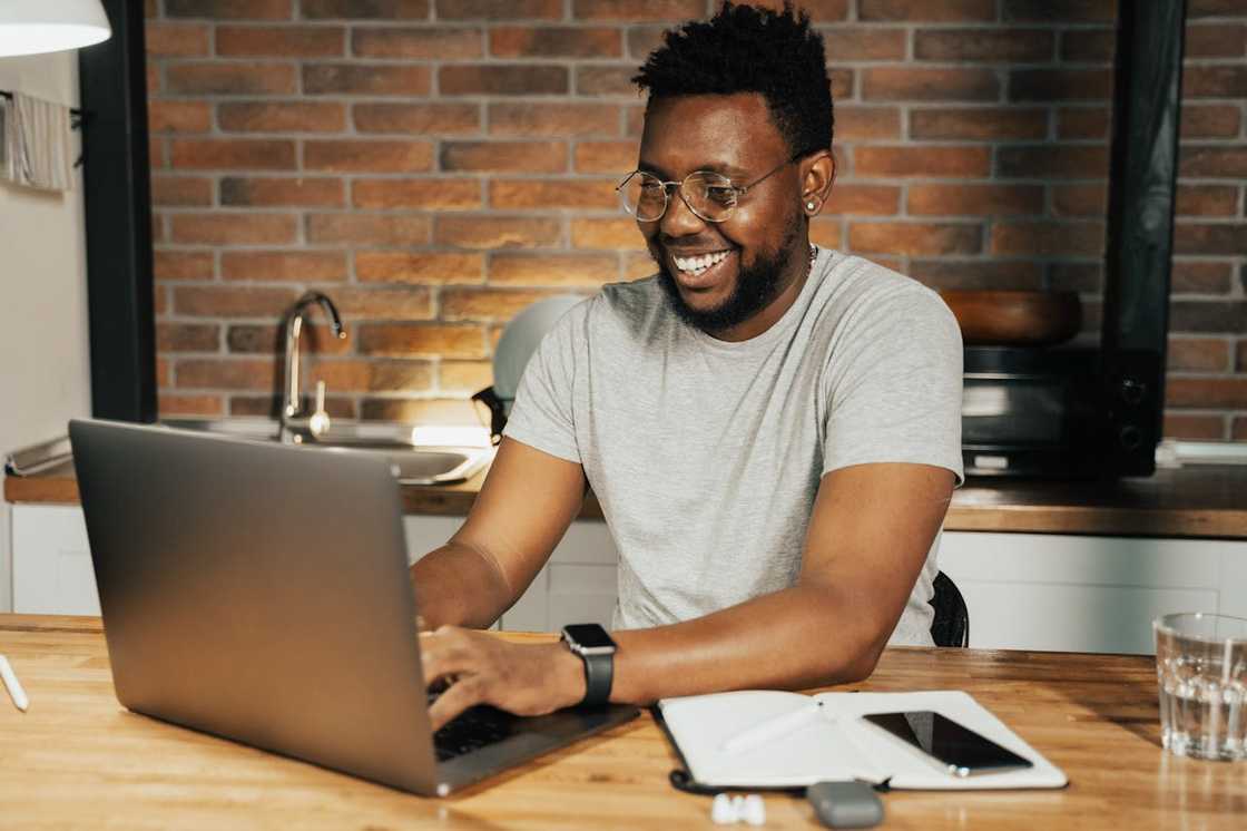 A young man reads an email on his laptop.