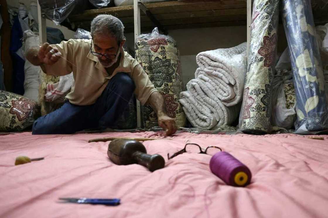 Mustafa al-Qadi, 67, often mends duvets under the soft light of a window during one of Lebanon's long power cuts Mustafa al-Qadi, 67, often mends duvets under the soft light of a window during one of Lebanon's long power cuts