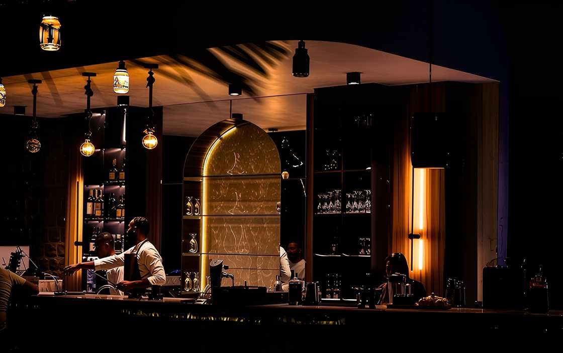 A bar tender serves a guest at the Gusto Restaurant bar area at night