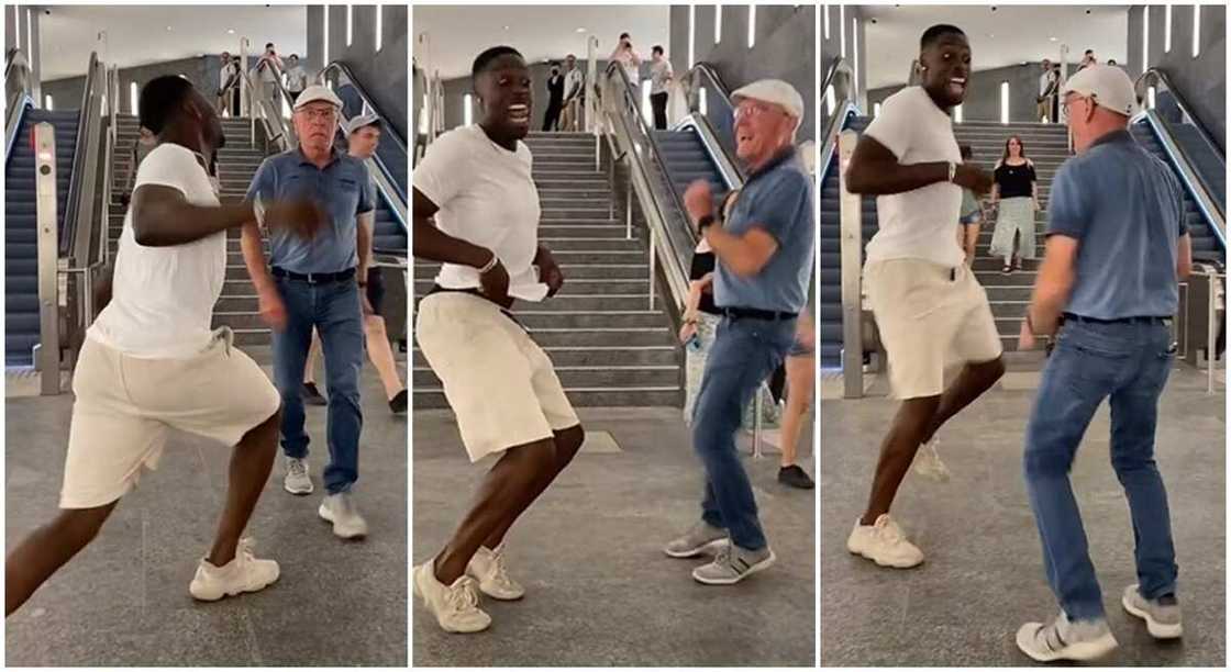 Black man and white man dancing in front of a busy elevator. Black man and white man dancing in front of a busy elevator.