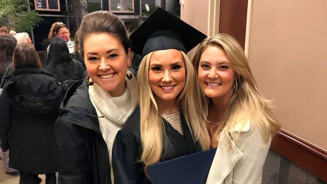 Mattie (L), Dani-Grace (C) and Alexandra Jackson (R) pose standing during a graduation ceremony.