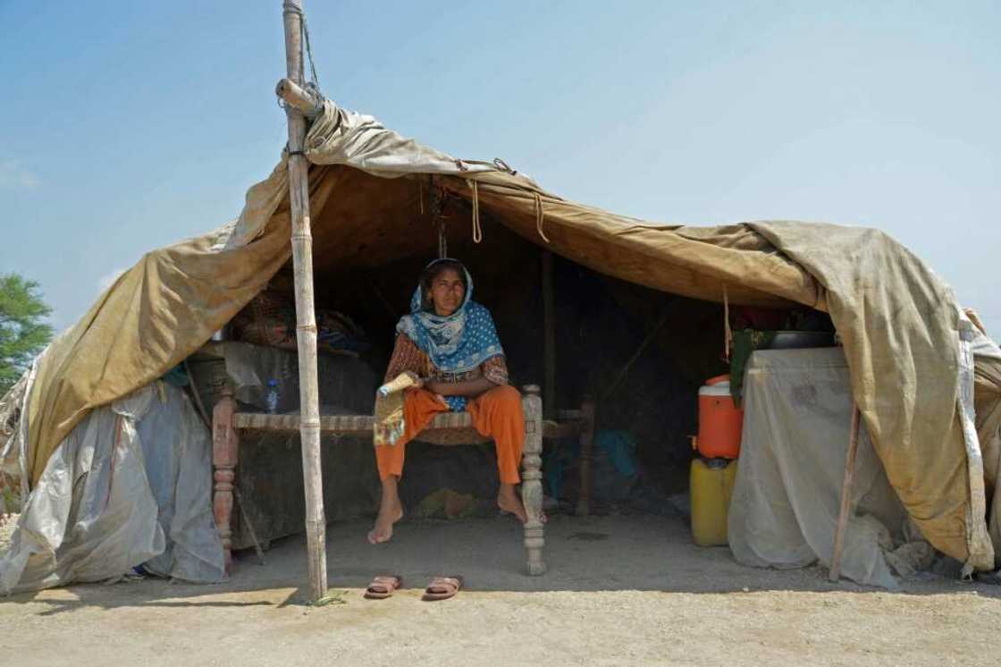 A woman shelters under a tarpaulin in Dera Allah Yar, Balochistan province A woman shelters under a tarpaulin in Dera Allah Yar, Balochistan province