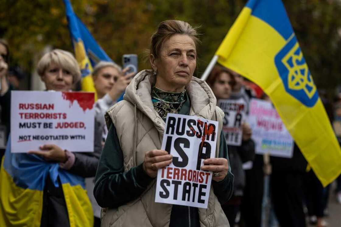 People hold Ukraine's national flags and placards during a demonstration, as they line up to cast ballots in a mock referendum about on whether Poland should annex Russia's embassy in Warsaw People hold Ukraine's national flags and placards during a demonstration, as they line up to cast ballots in a mock referendum about on whether Poland should annex Russia's embassy in Warsaw