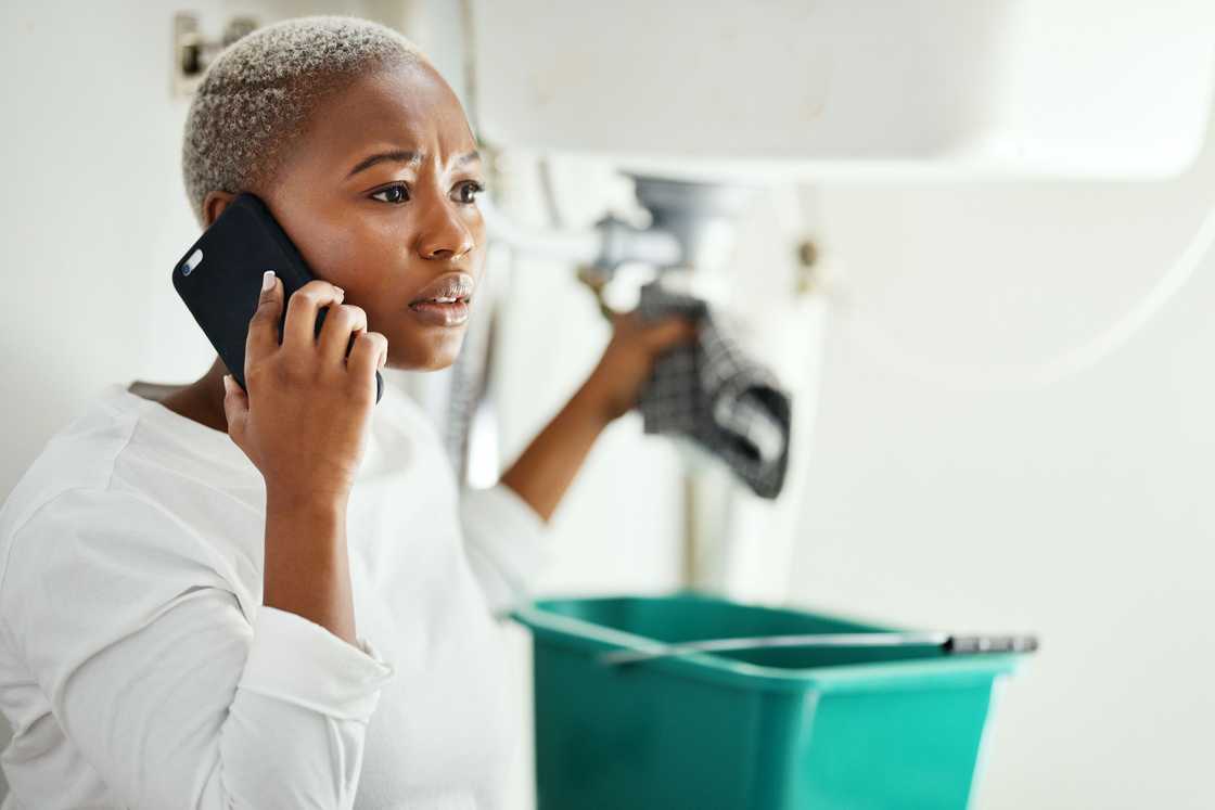 A lady receives a call while cleaning