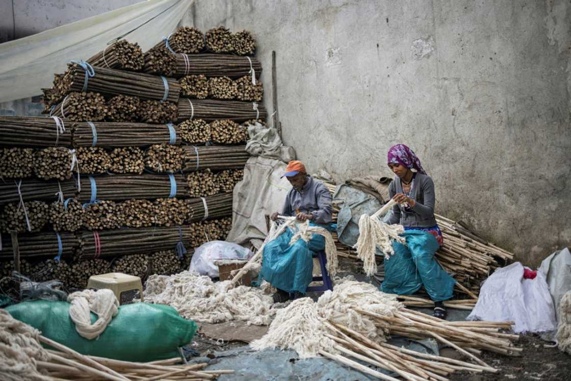 Workers make mops in a street near the Merkato district of Addis Ababa