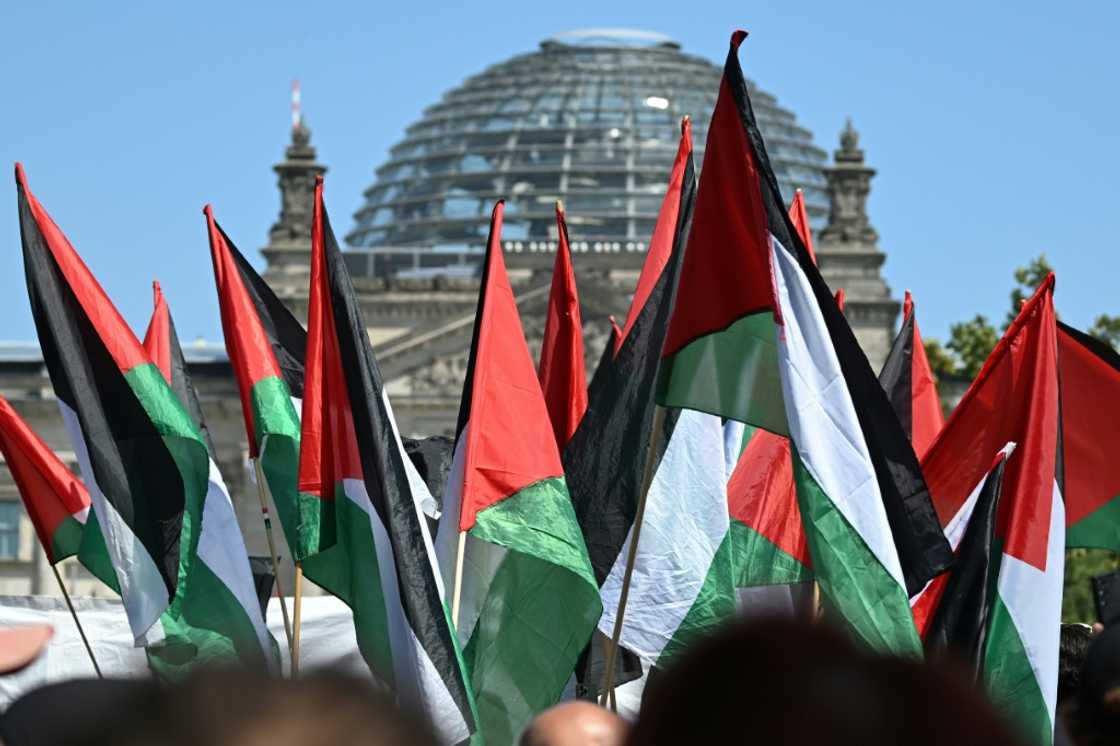 Protestors hold Palestinian flags at a 'United 4 Gaza!' rally in front of the Reichstag building in Berlin on June 21, 2025