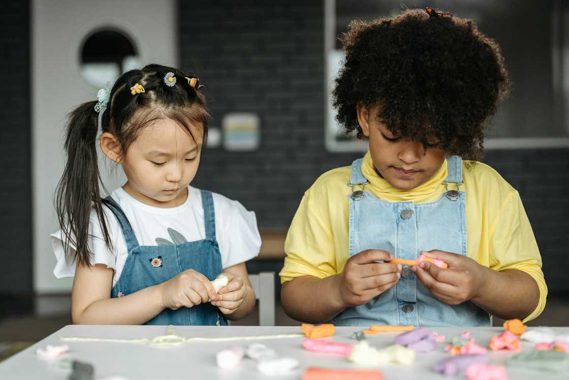 Preschool boy and girl modelling at a table Preschool boy and girl modelling at a table