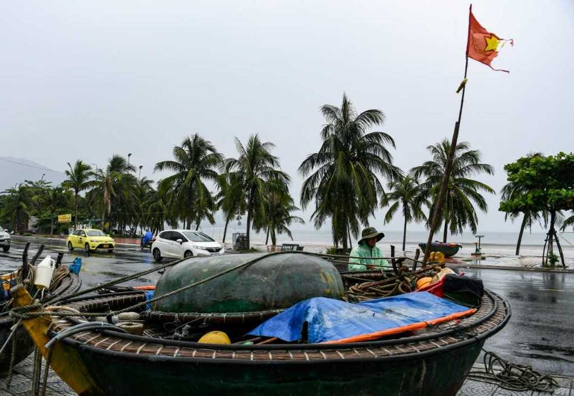 A fisherman ties his boat on a street to protect it from Typhoon Noru in Danang hours before the storm made landfall A fisherman ties his boat on a street to protect it from Typhoon Noru in Danang hours before the storm made landfall