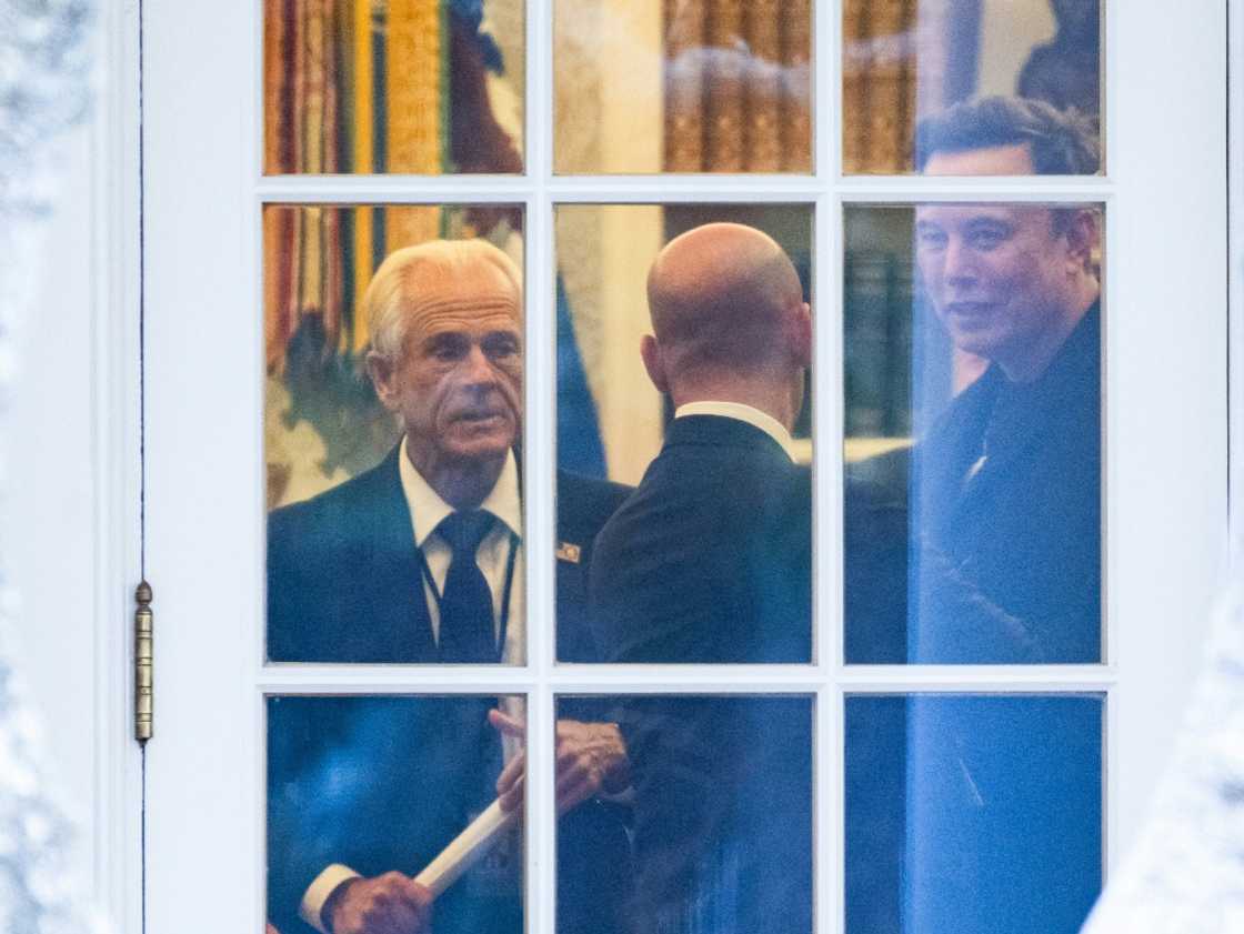 (FILES) (L-R) Senior Counselor to the President for Trade and Manufacturing, Peter Navarro, White House deputy chief of staff for policy and US homeland security advisor Stephen Miller, and Elon Musk speak inside the Oval Office of the White House before boarding Marine One with unseen US President Donald Trump in Washington, DC on March 14, 2025. Elon Musk on April 8 described Peter Navarro, a senior White House trade advisor, as "truly a moron" and "dumber than a sack of bricks" in a growing rift over Donald Trump's tariff policy. Musk, a key aide to the president, has signaled opposition to the tariffs, and the Tesla CEO hit out after Navarro described him as "not a car manufacturer" but "a car assembler." (FILES) (L-R) Senior Counselor to the President for Trade and Manufacturing, Peter Navarro, White House deputy chief of staff for policy and US homeland security advisor Stephen Miller, and Elon Musk speak inside the Oval Office of the White House before boarding Marine One with unseen US President Donald Trump in Washington, DC on March 14, 2025. Elon Musk on April 8 described Peter Navarro, a senior White House trade advisor, as "truly a moron" and "dumber than a sack of bricks" in a growing rift over Donald Trump's tariff policy. Musk, a key aide to the president, has signaled opposition to the tariffs, and the Tesla CEO hit out after Navarro described him as "not a car manufacturer" but "a car assembler."