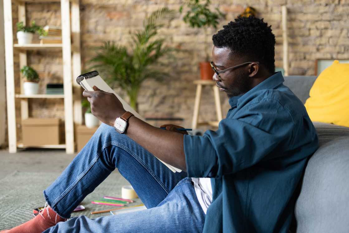 Person sketching quietly in a small library or park, sketchbook open Person sketching quietly in a small library or park, sketchbook open