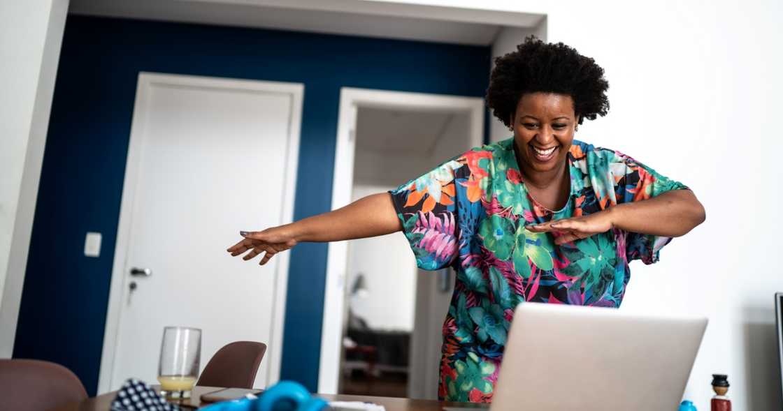 A woman dances during a Zoom call.