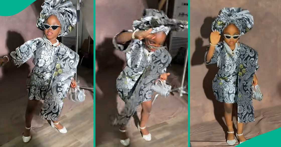Little Nigerian girl in Yoruba outfit struts like runway model.