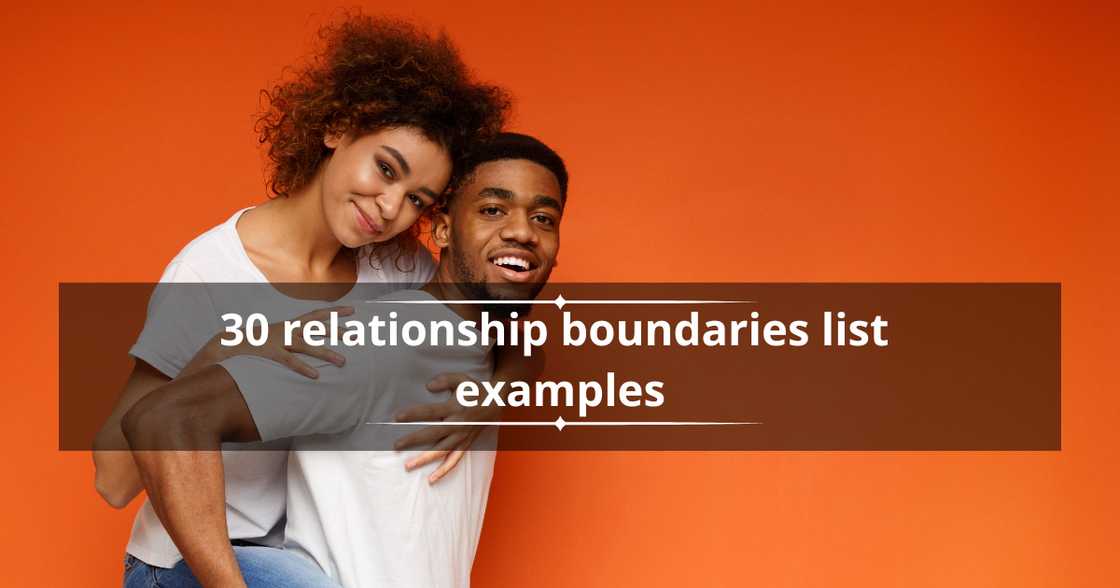A man and a woman pose while carrying each other against an orange background. A man and a woman pose while carrying each other against an orange background.