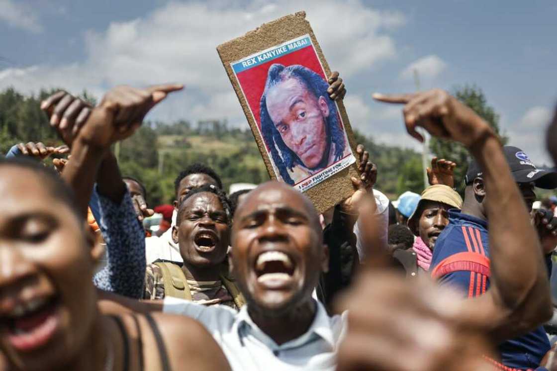 Family, friends and fellow protesters carry a photo of Rex Masaiwho was shot by the police