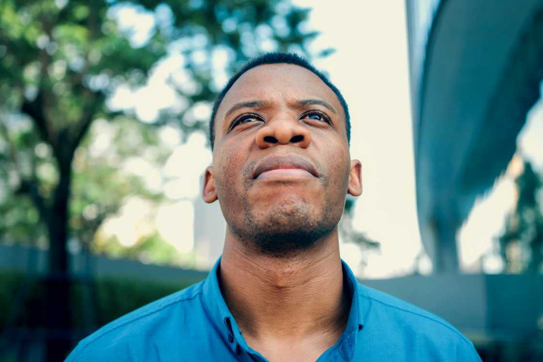 A young African man is looking upward A young African man is looking upward