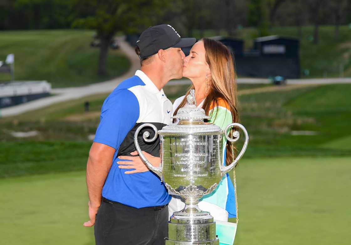 Brooks Koepka share a kiss with Jena Sims behind the Wanamaker Trophy Brooks Koepka share a kiss with Jena Sims behind the Wanamaker Trophy