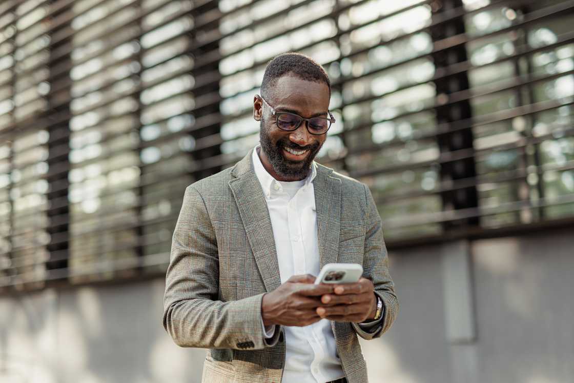 Young African-American businessmen using a smart phone on the go. Young African-American businessmen using a smart phone on the go.