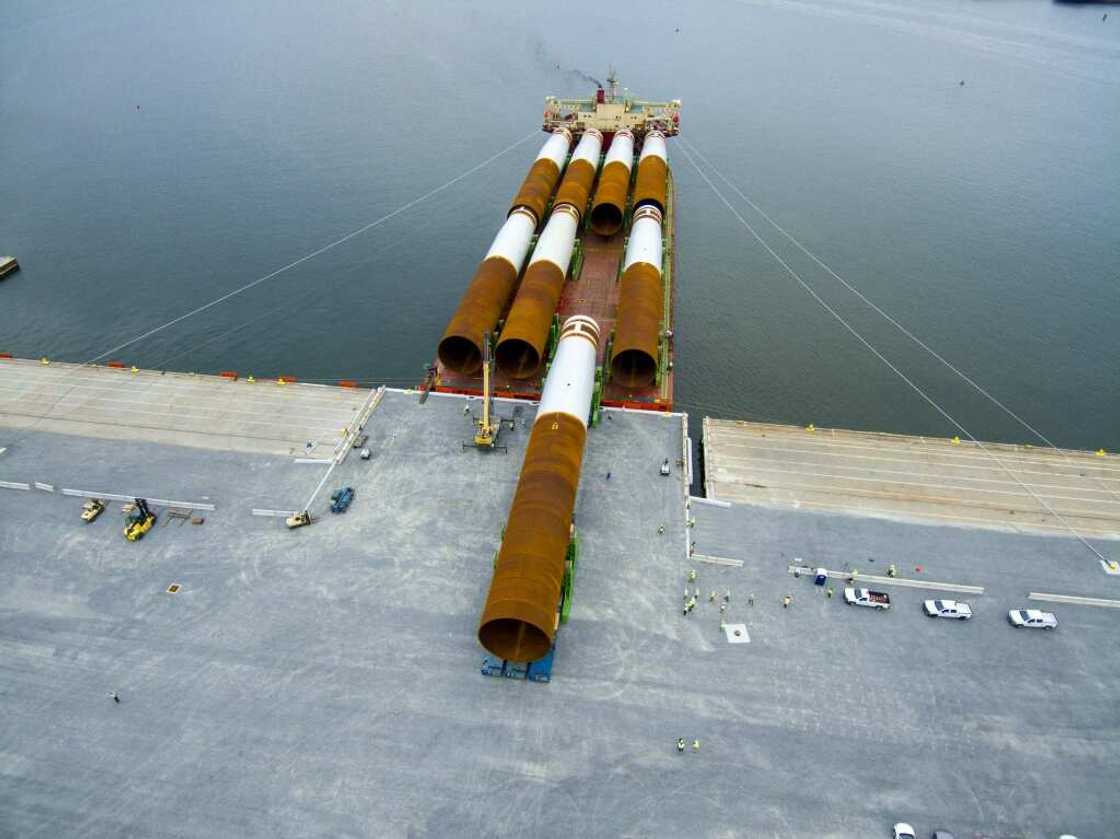 Steel monopile foundations for the Coastal Virginia Offshore Wind commercial project are offloaded at Portsmouth Marine Terminal in Portsmouth, Virginia