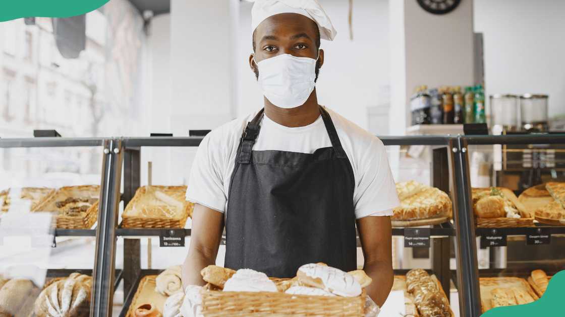 A man holding a tray with baked products