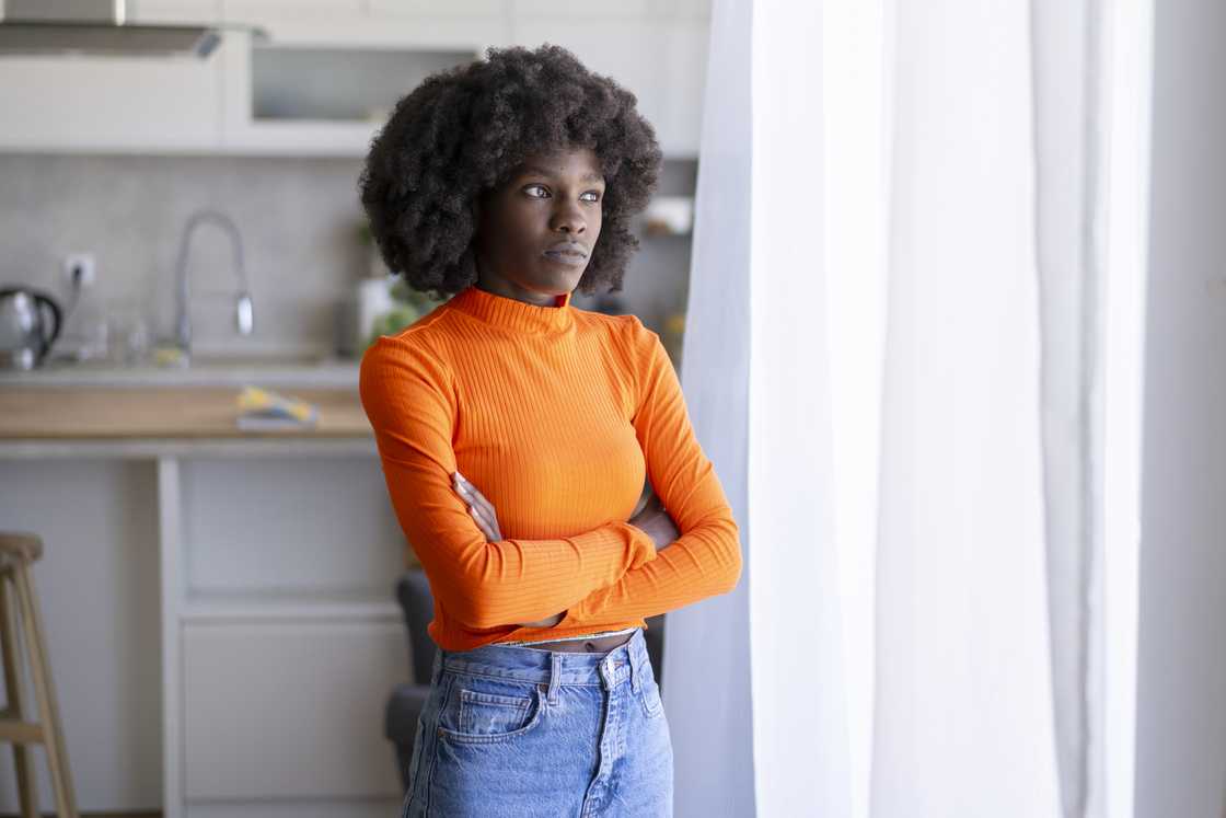 A serious young woman is standing