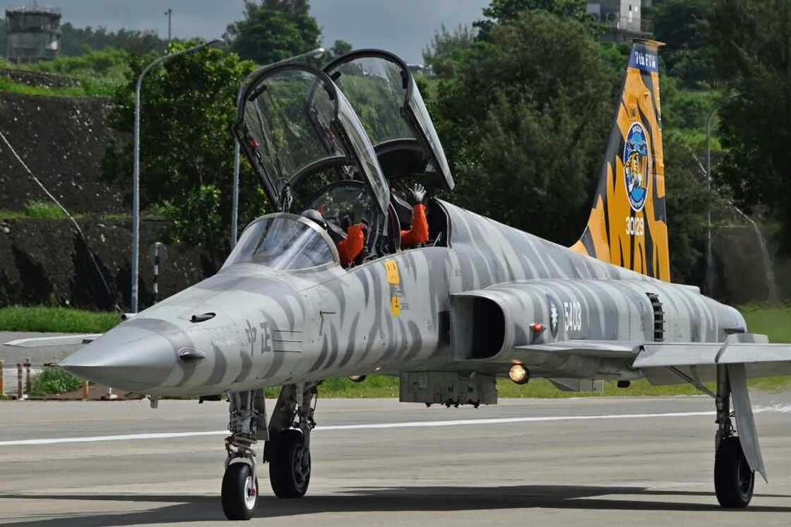 Pilots in a US-made Taiwanese Air Force F-5F Tiger II fighter-jet wave during a demonstration at an air force base in Taitung, eastern Taiwan, in July 2022