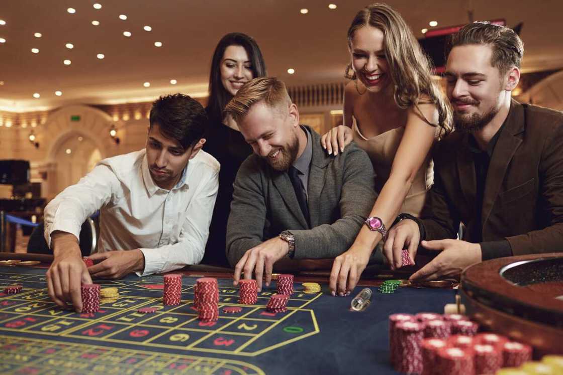 Happy friends play roulette in a casino