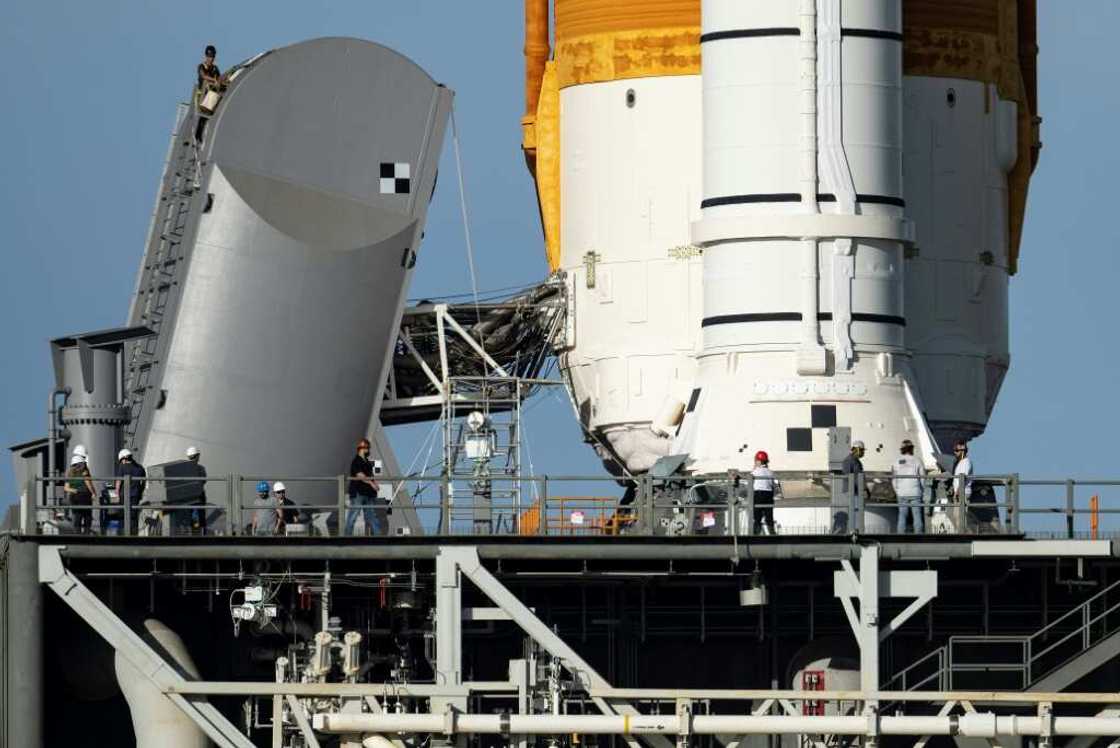 Engineers work on the Tail Service Mast Umbilical of the Artemis I unmanned lunar rocket as it sits on launch pad 39B at NASA's Kennedy Space Center