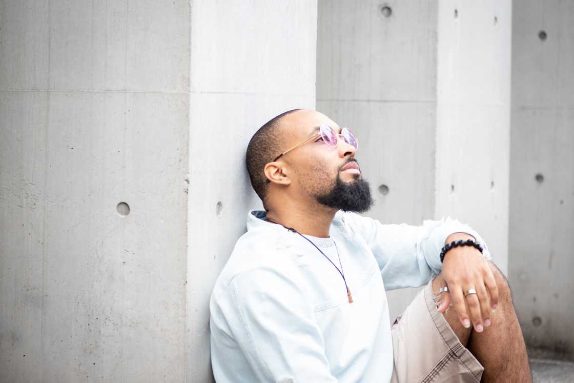 A man sitting outside on a sunny day, relaxing.